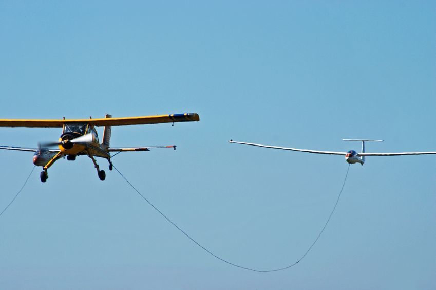 Sport plane towing a glider in an airshow.