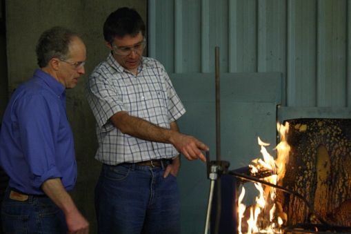 2 scientists and a burning sofa as part their fire experiment
