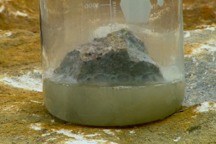 Dilute acid placed on a sample of limestone rock in a jar