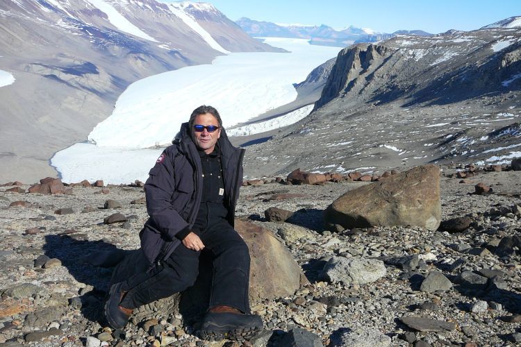 Prof John Montgomery sitting in rocks in Antarctica