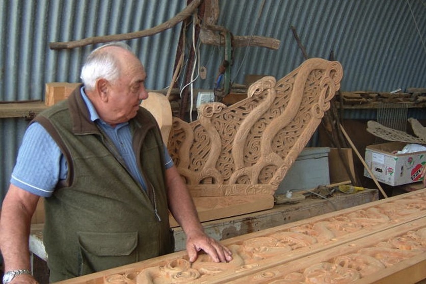 Waka builder Hekenukumai Busby in workshop with waka carving