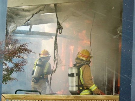 Two firefighters at an interior house fire.