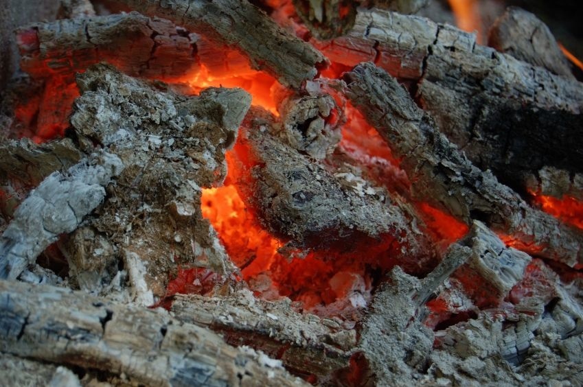 Burning coal in hot campfire flame.