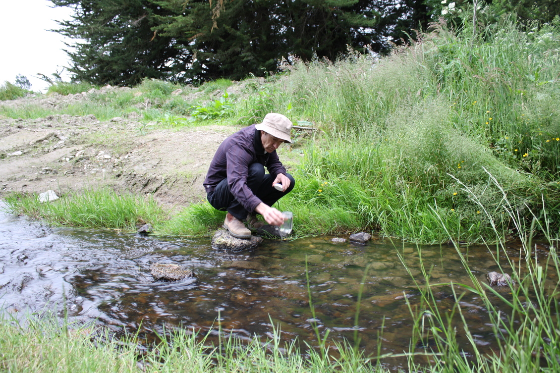 Dr Ross Monaghan takes a water sample to test for nutrients.