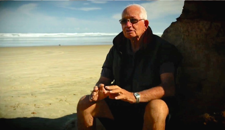 Toheroa kaitiaki Jim Te Tuhi stitting by a beach.