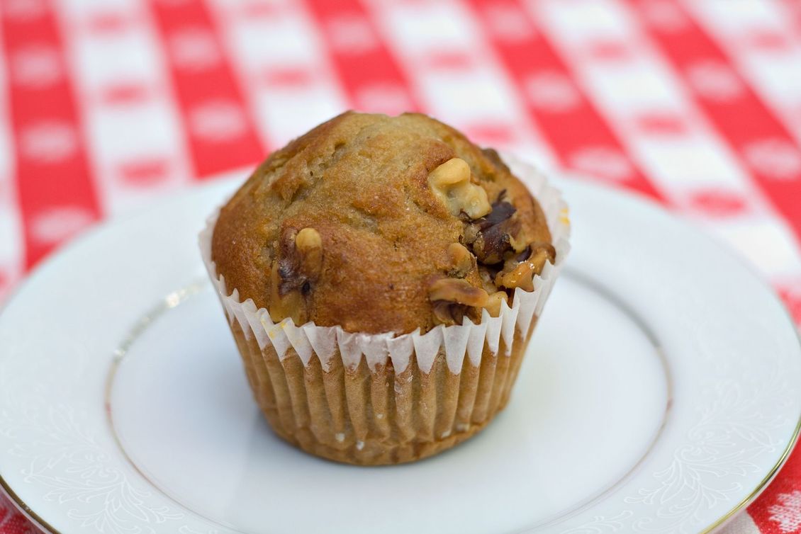 Banana and walnut muffin on a white plate on red and white cloth