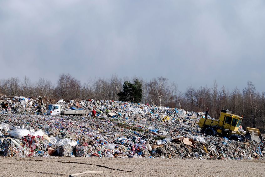 A modern landfill with truck and bulldozer.