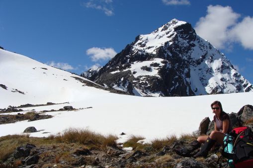 Tramper on snowy Travers Saddle with view of Mt Travers mountain