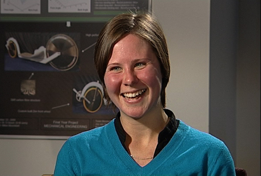 Dr Lindsey Underwood smiling with cycle poster behind