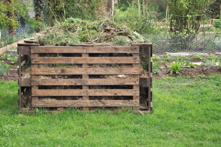Wooden composter for organic waste in a garden.