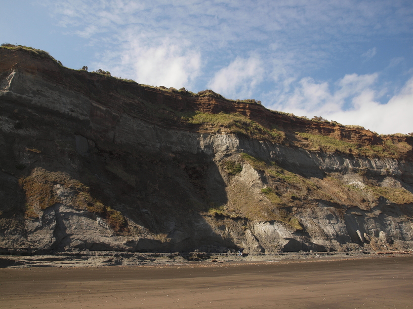 Geologist working below a cliff near Whanganui, New Zealand. 