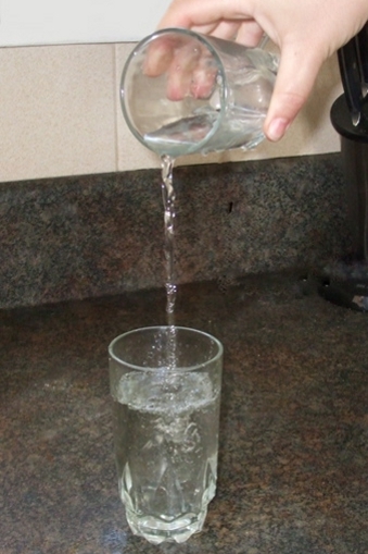 Pouring water from one glass into another. 