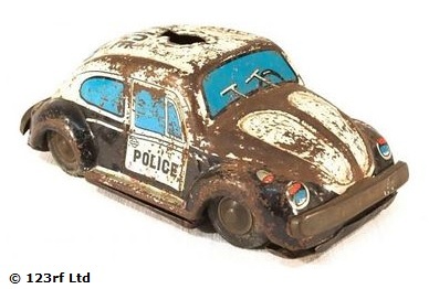 An old rusty toy police car on a white background. 