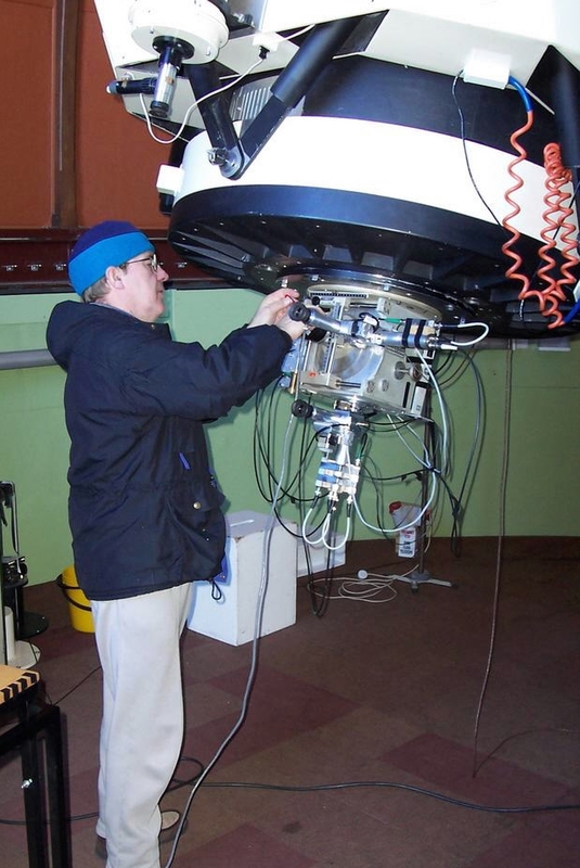 Scientist using a photometer attached to a telescope.