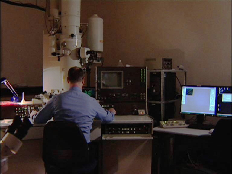 Scientist working on a transmission electron microscope.