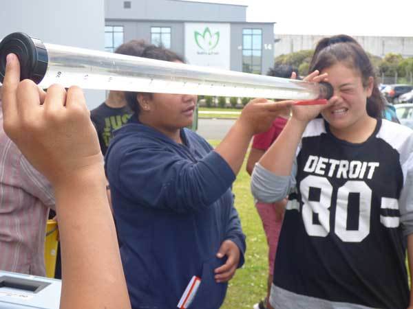 Students testing water clarity with a 1 m long acrylic tube.