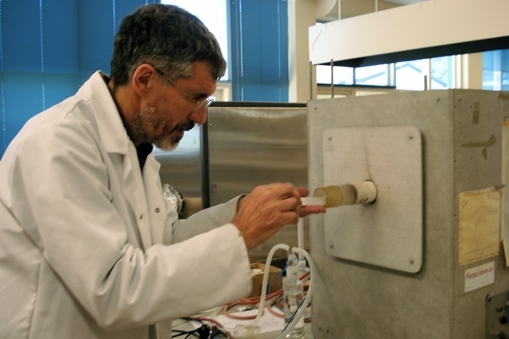 Scientist loads furnace with sample discs of advanced ceramics