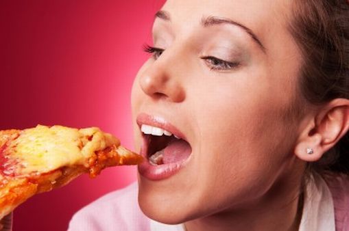 Woman about to eat a piece of pizza.