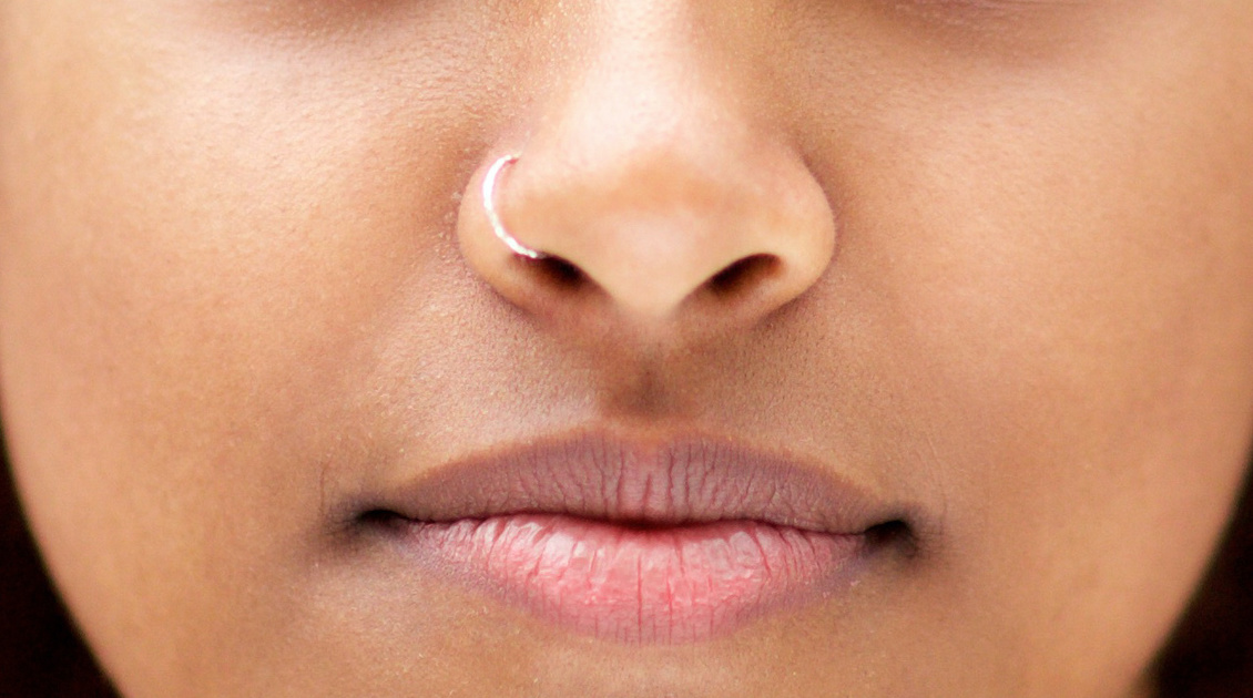 Close up of a human nose with silver nose ring.
