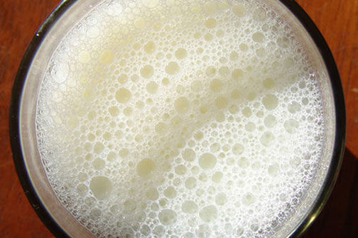Top of a glass of frothy milk.