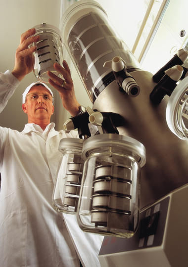 A Tatua Dairy Cooperative scientist checking a lab flask.