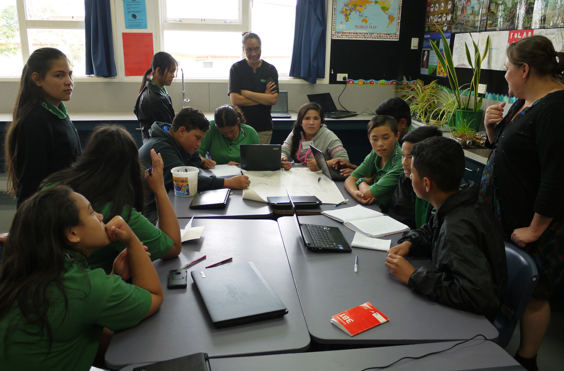 New Zealand students working around a table in class.