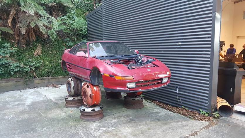 The REV it UP project car, a Toyota MR2 on stands outside.
