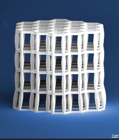A hexagonal microtruss structure, white on blue background.