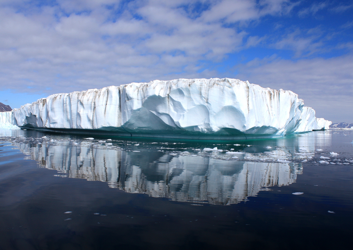 Greenland ice shelf reflected in water.