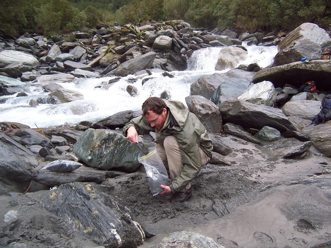 Scientist Isaac Larsen collects sand samples in Southern Alps