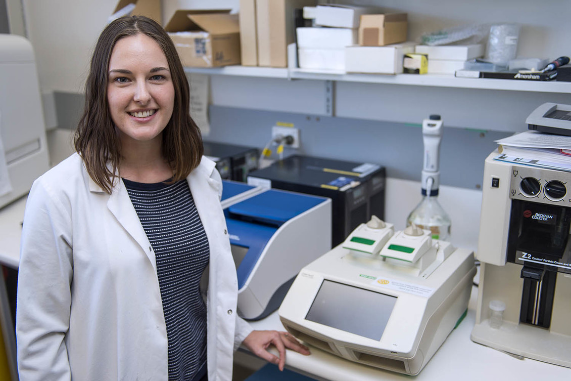 Scientist with a PCR machine in a lab.