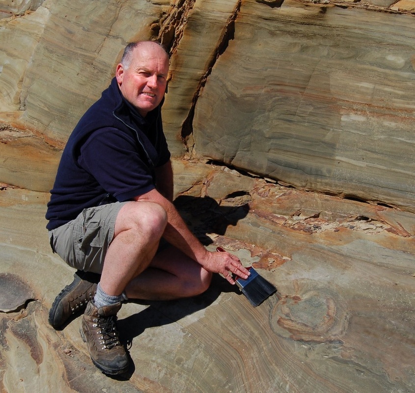 Dr Greg Browne and dinosaur footprint in sandstone, Nelson, NZ