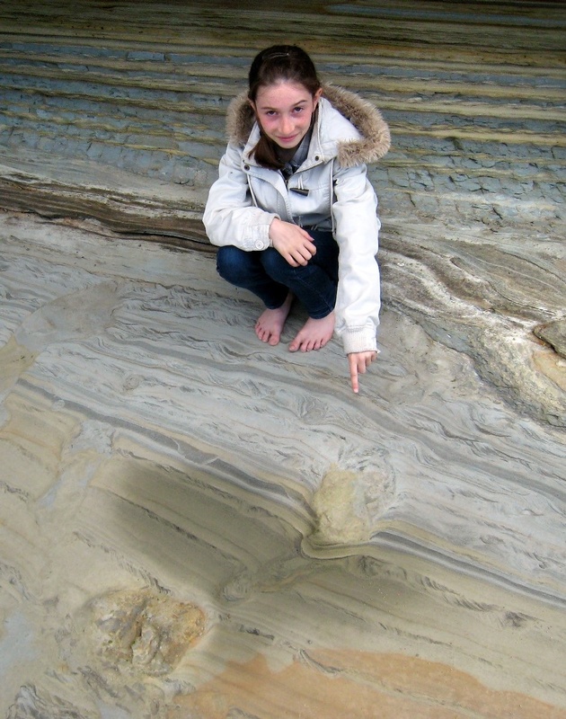 Young girl and 70 million-year-old dinosaur sandstone footprints