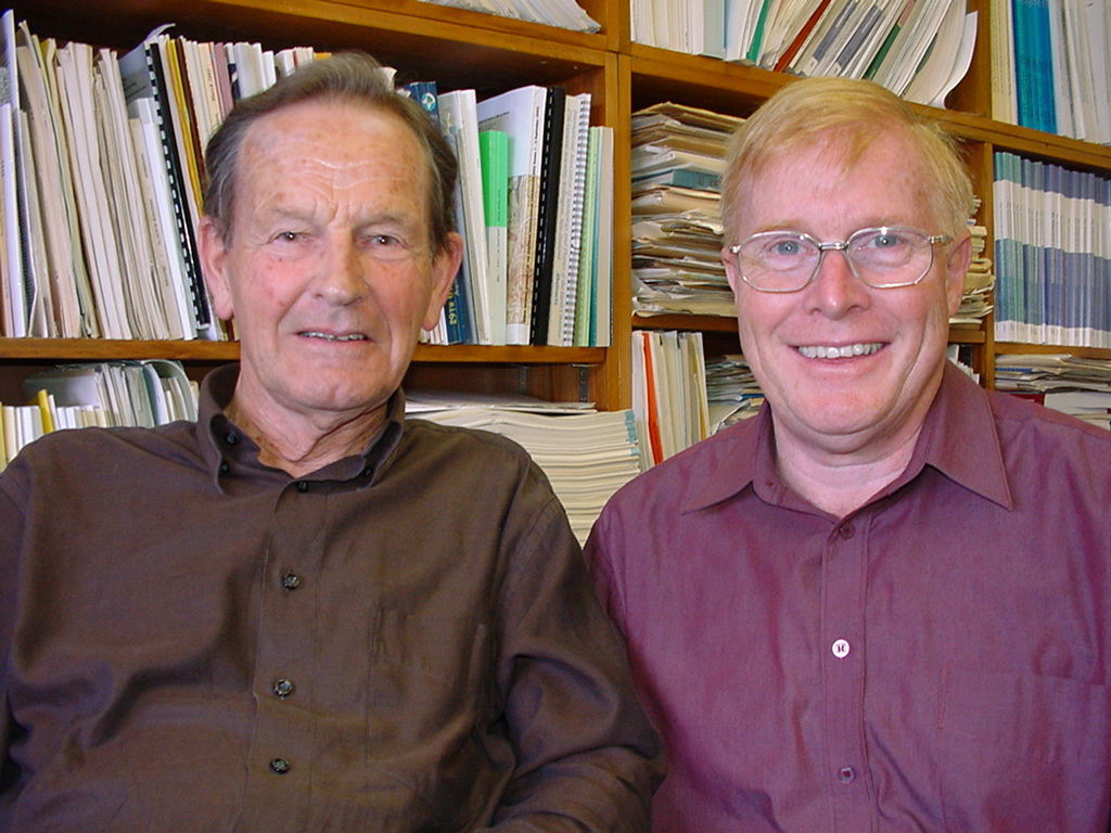 Frank Evison and David Rhoades in office with bookcase behind