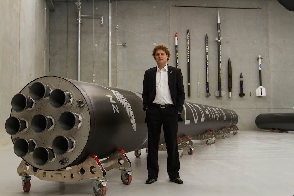 Peter Beck, Rocket Lab standing by a horizontal Electron rocket