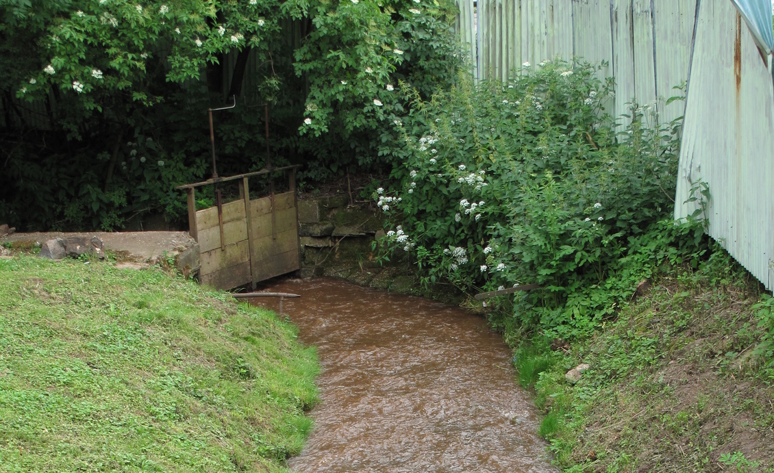 Muddy stream with a barrier at end.