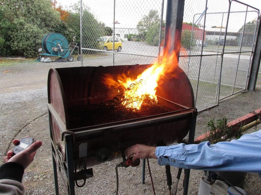 Scientists measuring how long a fire burns on a plant barbecue.