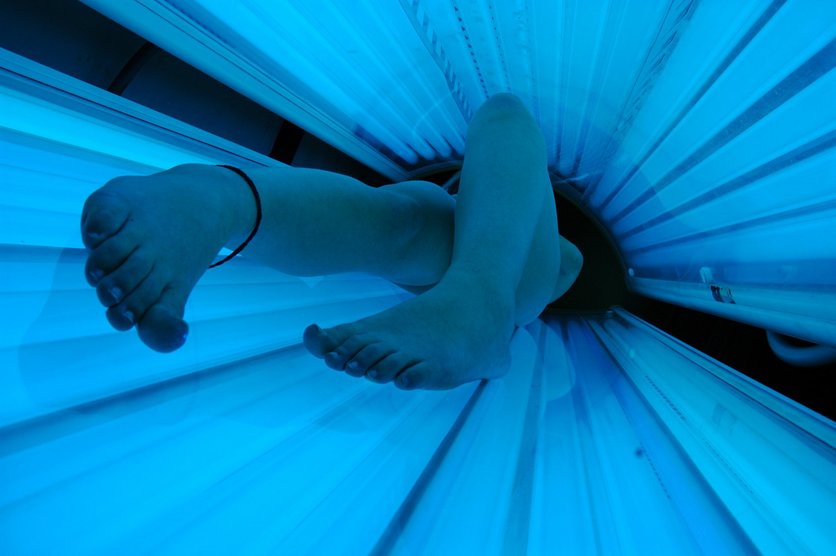 Feet and legs of someone inside a sunbed.