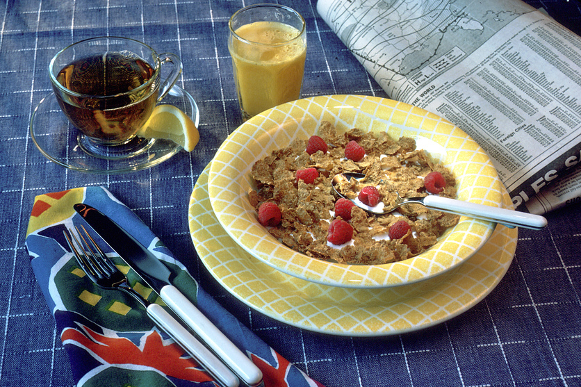 Black tea, orange juice and cereal breakfast meal.