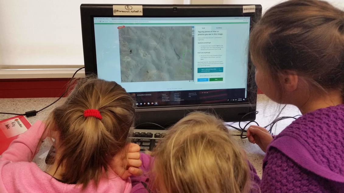 3 young students and a computer identifying beach litter online