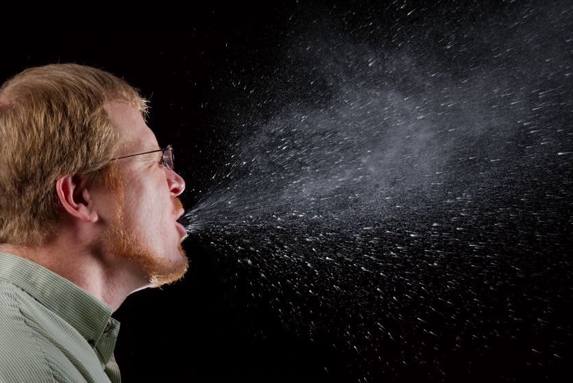 Sneezing man expells salivary droplets in a large cone-shape