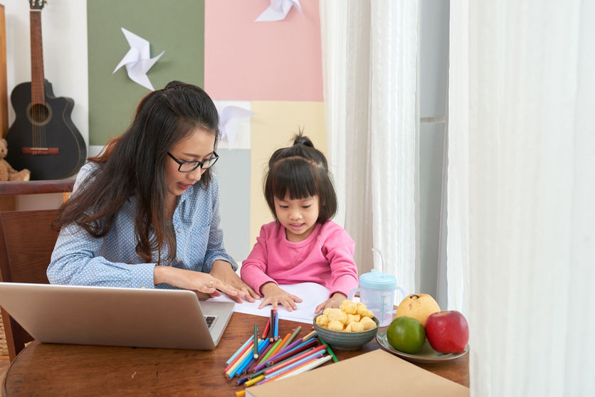 Adult and child with computer, colourful pens and 2 food bowls