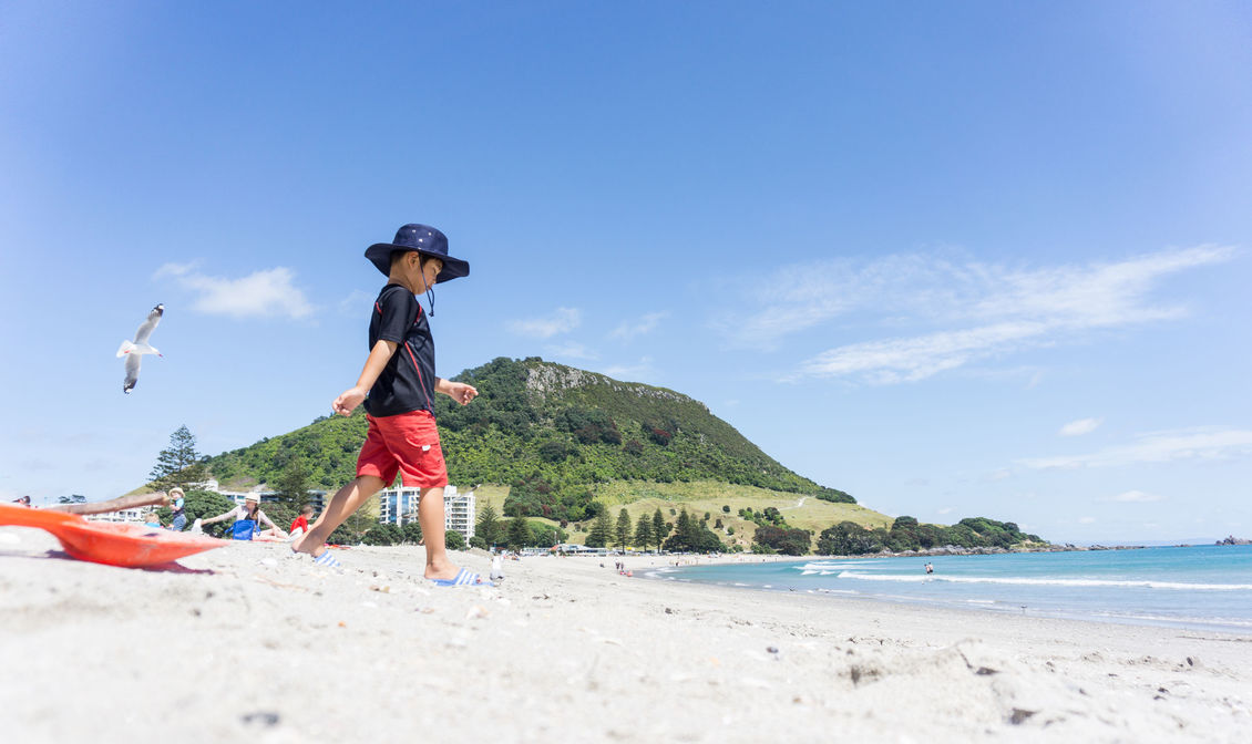Child playing at Mount Maunganui beach, New Zealand.