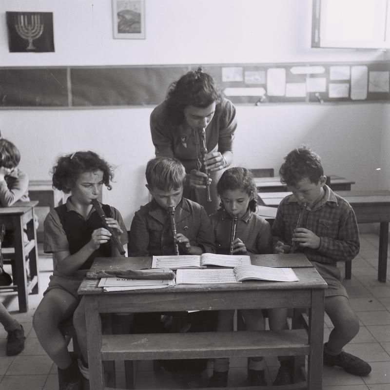 Black and white photo of children learning recorder at school