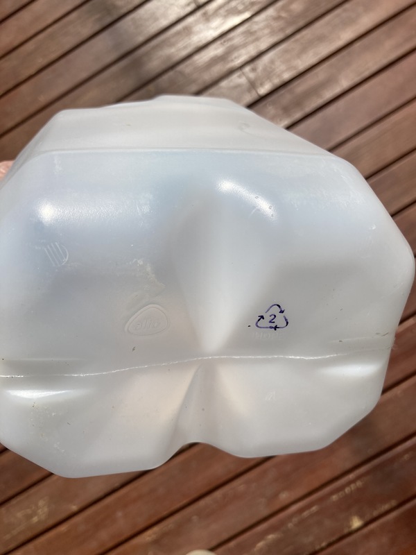 bottom of a white plastic bottle showing recycling code stamp