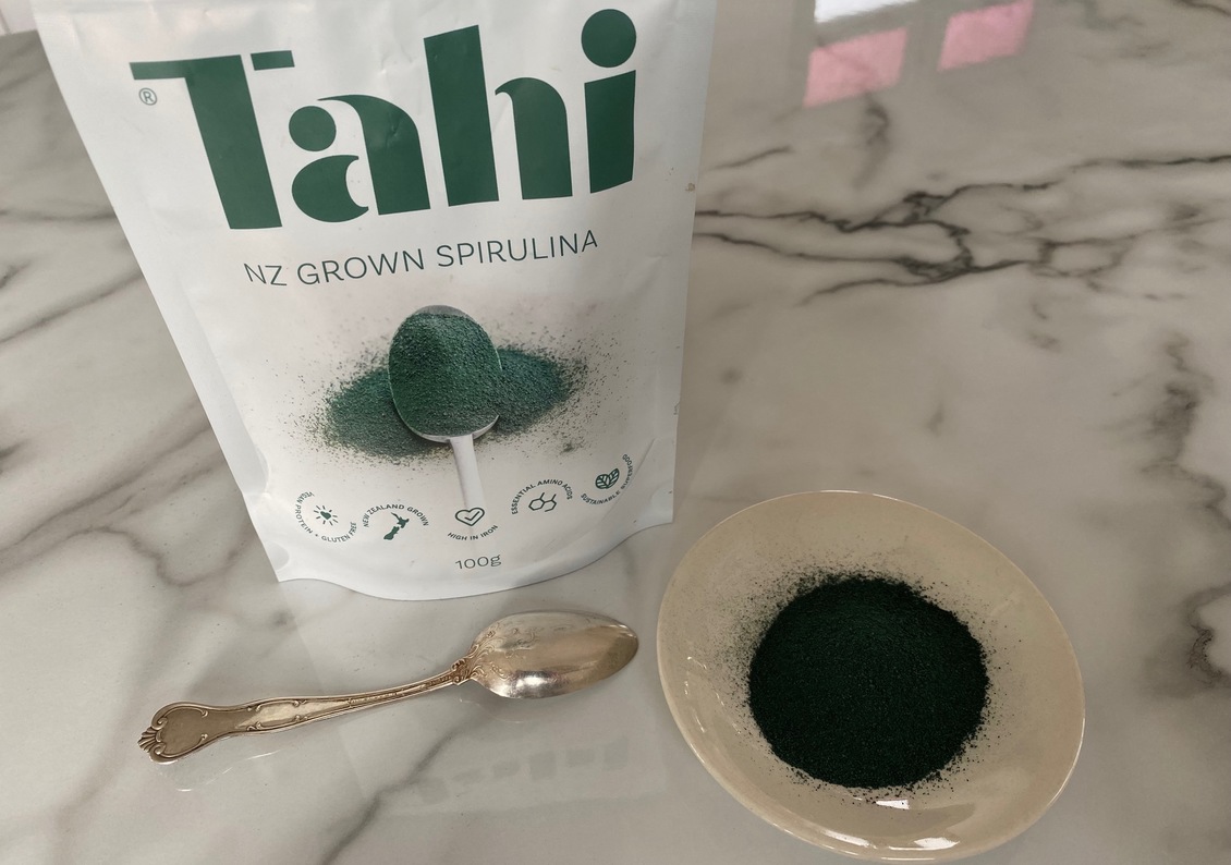 Packet of Tahi Spirulina powder, with spoon and bowl.