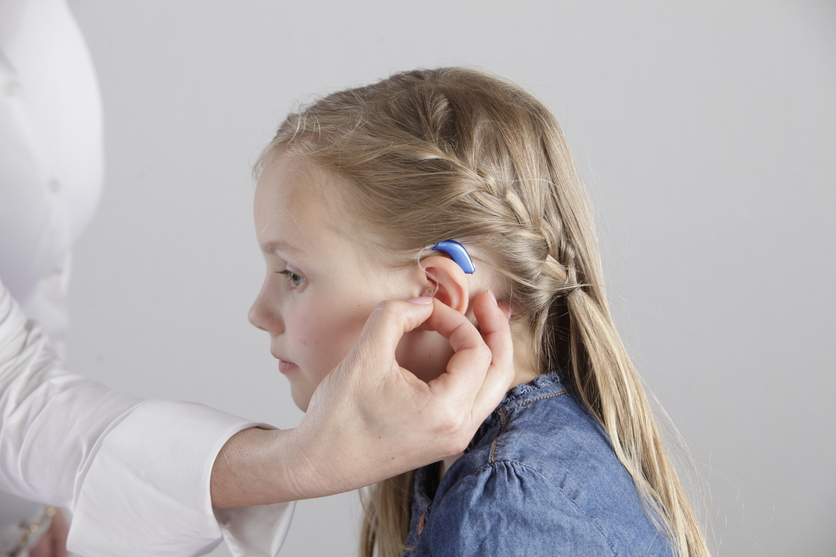 Child being fitted with a behind-the-ear hearing aid