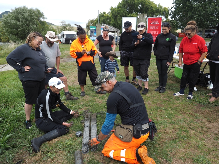 Iwi and members of the public viewing a lake sediment core.