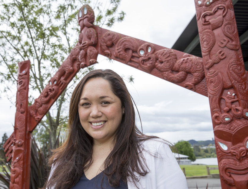 Woman standing near waharoa/gateway.