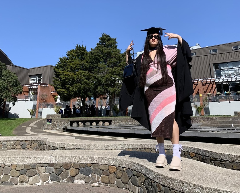 Milly dressed in university BSc (Hons) graduation cap and gown.